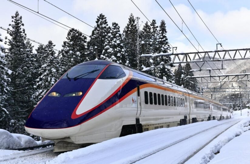 A High Speed Shinkansen Train Glides Through A Snowy Landscape, Showcasing Its Sleek Design Against The Winter Scenery