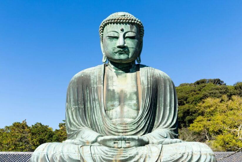 A Large Buddha Statue Seated In A Park, Surrounded By Greenery, Symbolizing Peace And Tranquility In Japan