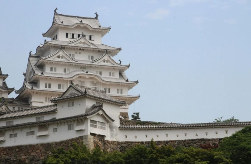 A Large White Himeji Castle Featuring A Prominent Tower Atop Its Structure Against A Clear Blue Sky