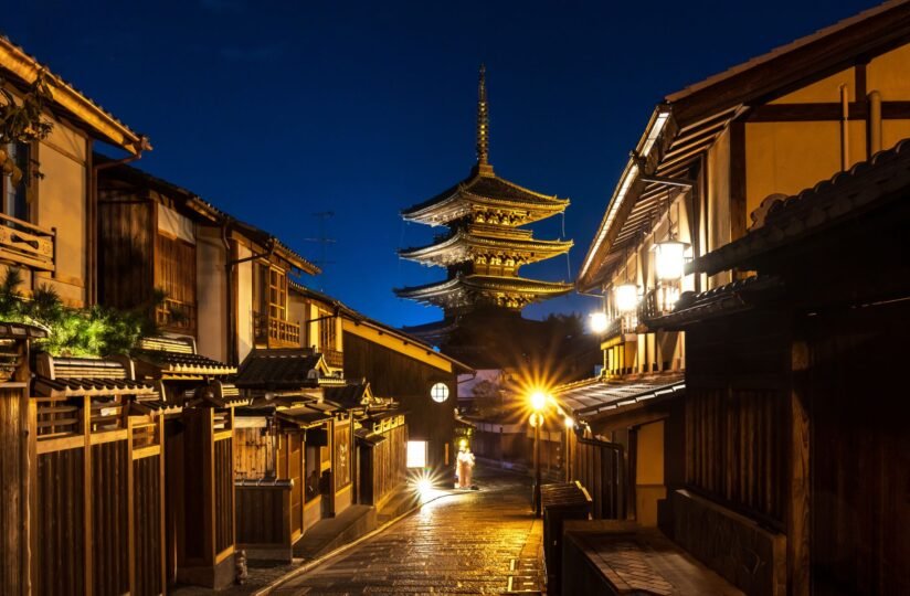 A Narrow Street At Night With Yasaka Pagoda Illuminated In The Background, Creating A Serene Atmosphere