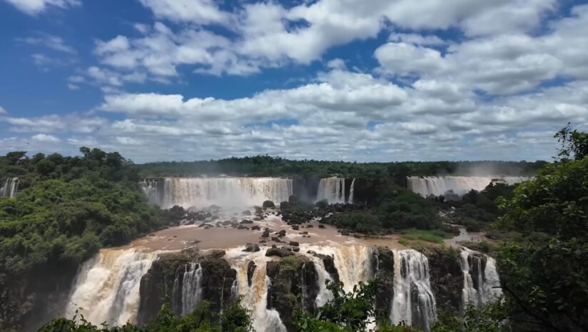 A Stunning View Of Iguazu Falls, Where Water Flows Dramatically Down The Rocky Face Of The Waterfall