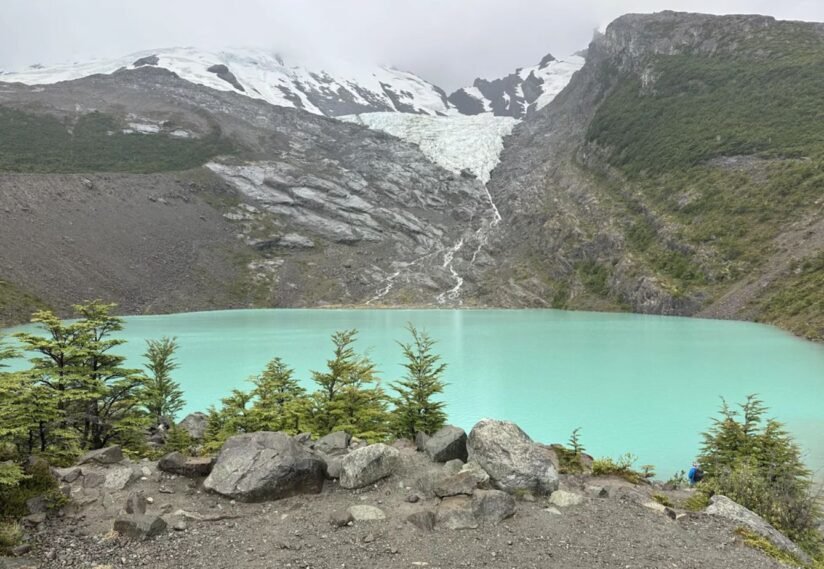 A Tranquil Lake With The Huemul Glacier Rising In The Background, Capturing The Essence Of The Hiking Experience