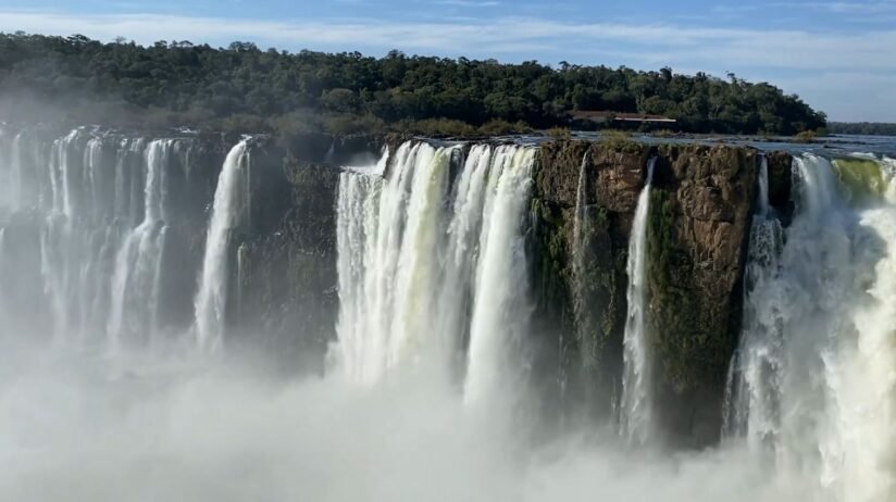 Iguazu Falls In Argentina, Featuring Powerful Waterfalls Surrounded By Vibrant Rainforest And Mist Rising From The Cascades
