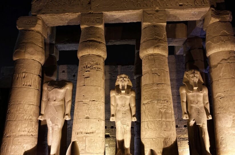 Night View Of Luxor Temple With Statues Of Egyptian Gods Beautifully Lit, Highlighting Their Intricate Details