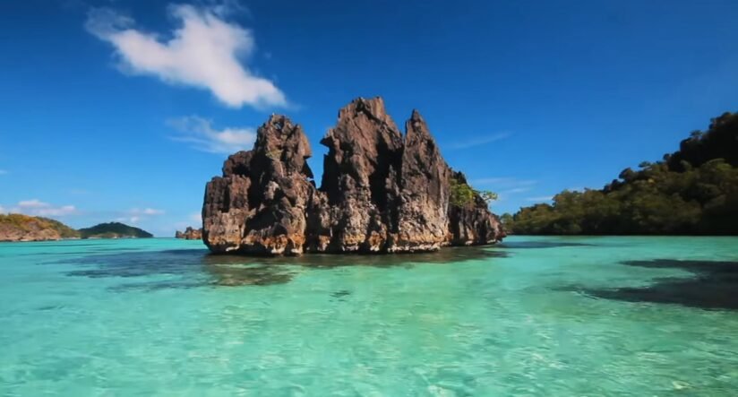 Ocean Rock Formations Are Enveloped By Crystal Clear Water At Misool Island, Raja Ampat