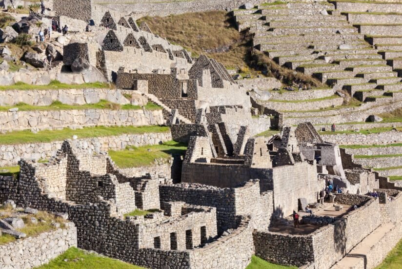 The Ancient Ruins Of Machu Picchu, Nestled In The Andes Mountains Of Peru, Showcasing Stone Structures And Lush Greenery