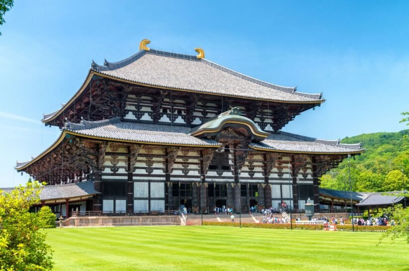 Tōdai Ji Temple In Nara, Japan, Showcasing The World's Largest Wooden Buddha Temple, Surrounded By Lush Greenery