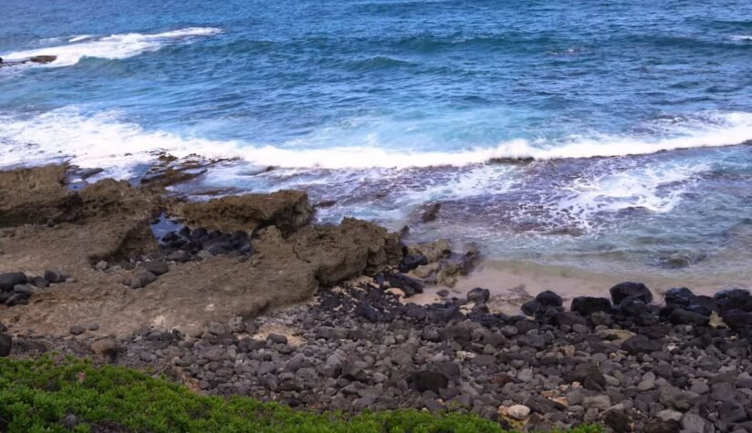 Waves Crash Against A Rocky Shoreline Along The Kaʻena Point Trail, Showcasing The Rugged Coastal Landscape
