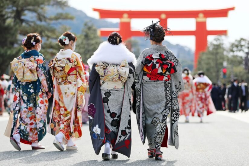 Women In Colorful Kimonos Stroll Down A Street, Showcasing Traditional Japanese Attire And Cultural Heritage